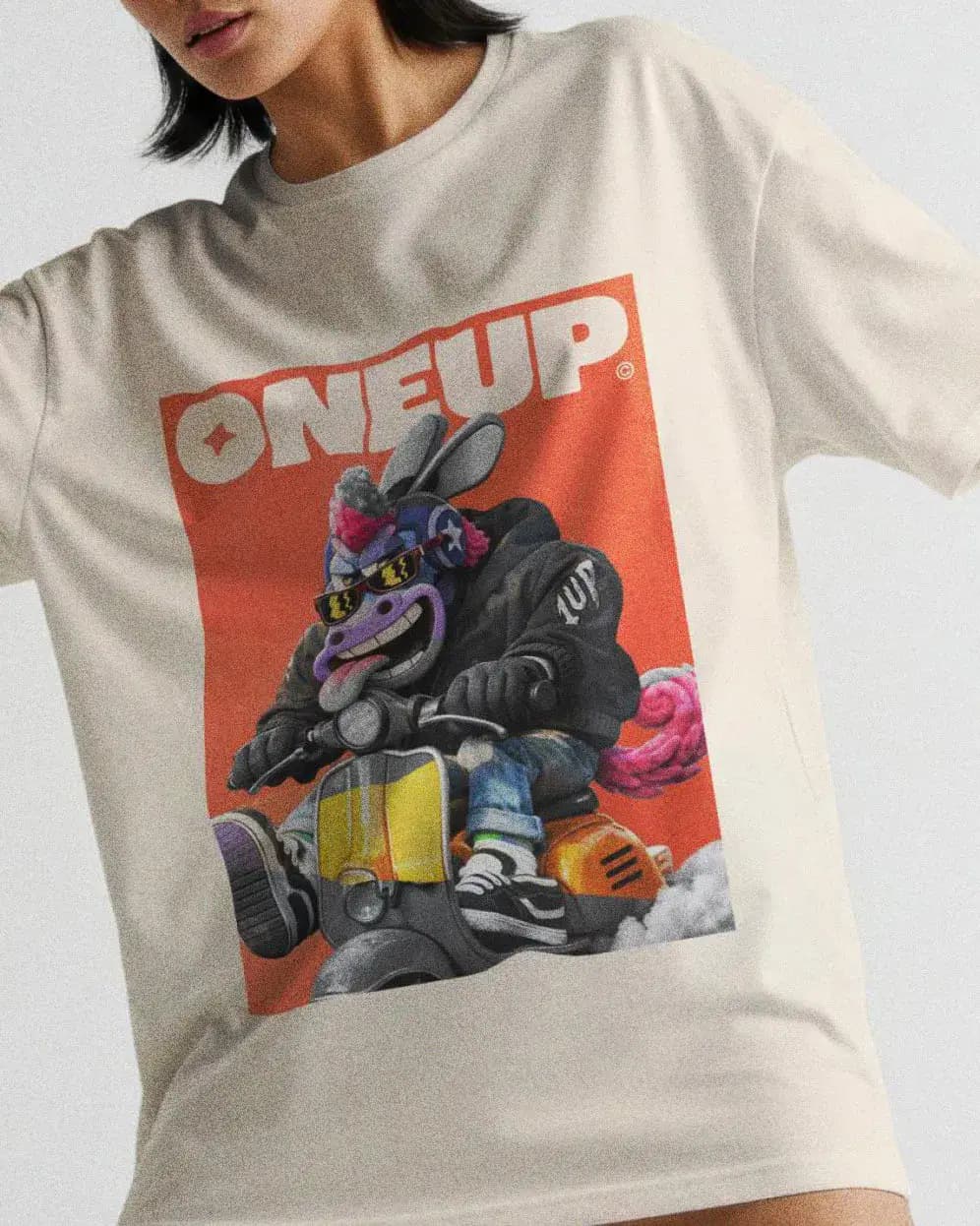 Close-up of white ONEUP t-shirt with colorful mascot graphic and streetwear-inspired design.